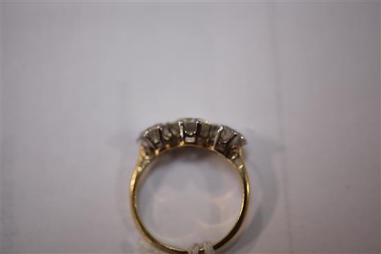 An 18ct gold and platinum three stone diamond ring, size L.